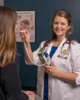 Katie taking a student's temperature